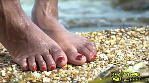युवा और गांठदार टीन समुद्र तट पर अपने पैरों को गीला करती हुई