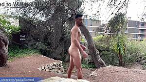 Seorang pria berotot memamerkan kebugarannya dengan melakukan squat telanjang di alam terbuka yang indah